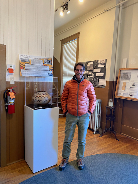Robert McDaniel standing next to San Ildefonso pot